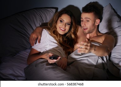 Close Up Of Couple Watching Tv In Bed