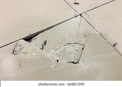 Close up of a cracked ceramic tiles floor surface due to improper residential construction material. - Shutterstock ID 643817290