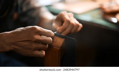 Close up craftsman meticulously stitching leather with a needle and thread. Leather craft concept - Powered by Shutterstock