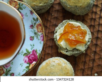 Close Up Of Cream Tea, Afternoon Tea With Scone, Clotted Cream, Jam And A Cup Of Tea On Wooden Table