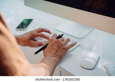 Nahaufnahme - Kreative Künstlerin, die auf einem Laptop arbeitet und Verweise sucht und digitale Stifte hält.