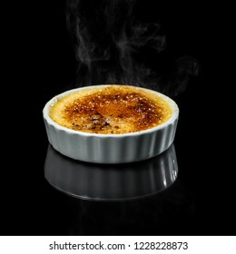 Close Up Of A Creme Brûlée With Smoke From The Burned Sugar Isolate Don A Black Background