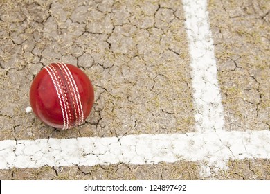 Close Up Cricket Ball On Pitch With Copy Space