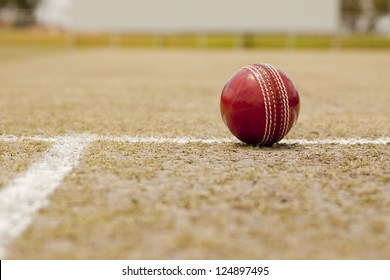 Close Up Cricket Ball On Pitch With Copy Space