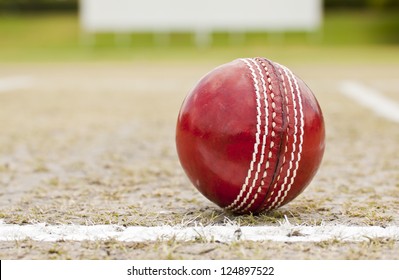 Close Up Cricket Ball On Pitch With Copy Space