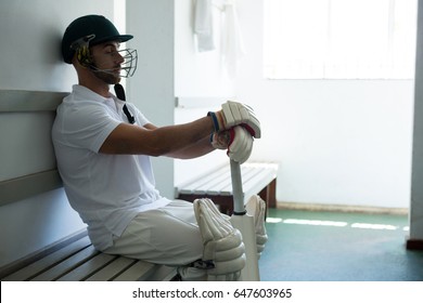 Close up of cricket player sitting on bench at locker room - Powered by Shutterstock