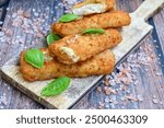 Close up of   Crispy breaded  deep fried fish fingers with breadcrumbs served  with remoulade sauce and  lemon Cod Fish Nuggets on rustic wood table background