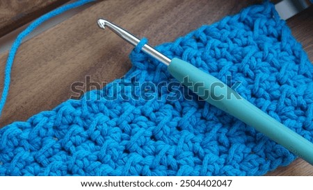 Close up of crochet work in progress with crochet hook and macrame cord