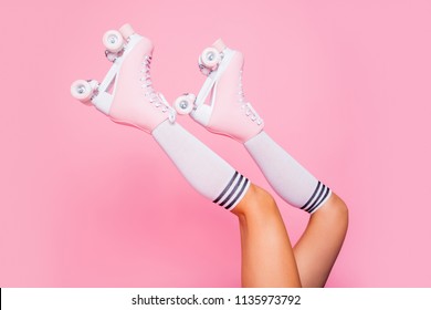 Close Up Crop Photo Of  Legs In Vintage Quad Roller Skates Shoes Isolated On Pink Background