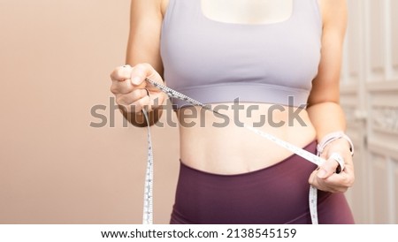 Close up crop shot of a healthy asian woman's body, chest, waist, abdomen, hip. She holding a measurement tape as she will workout targeting weight loss and better health. Dieting, Exercise, Home. Stock photo © 