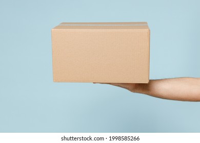 Close Up Cropped Employee Courier Male Hold In Hand Brown Clear Blank Paper Empty Cardboard Box Isolated On Blue Color Background Packaging Mock Up Delivery Service Concept Copy Space Advertising Area