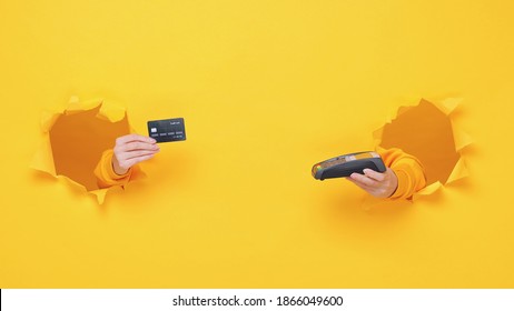 Close up cropped female hand hold wireless bank terminal to process acquire credit card payments pay isolated through torn yellow background studio Copy space place for text or image workspace mock up - Shutterstock ID 1866049600