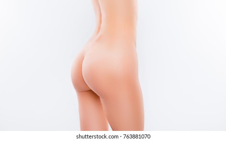 Close up cropped half turned photo of perfect sexy slim woman's body and tightened naked bottom, isolated on white background