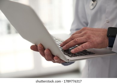 Close up cropped head of general practitioner typing on notebook while standing during working day - Shutterstock ID 1789776317