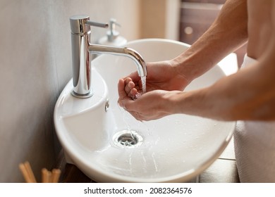 Close Up Cropped Image Of Young Millennial Guy Washing Hands Under Running Water In Modern Sink. Arab Man Gathering Water In Hands To Wash Face. Morning Personal Hygiene Routine