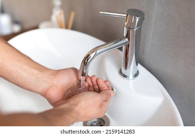 Close Up Cropped Image Of Young Millennial Guy Washing Hands Under Running Water In Modern Sink. Arab Man Gathering Water In Hands To Wash Face. Morning Personal Hygiene Routine