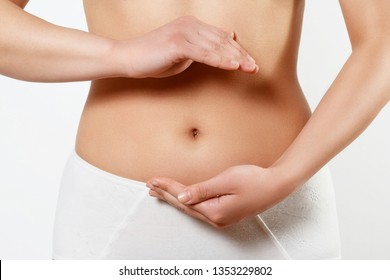 Close up cropped photo of beautiful woman's slim stomach, using hands she is showing a balance. The concept of healthy eating, diet. Early pregnancy. on white background