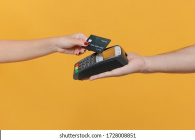 Close up cropped photo of female and male hold wireless modern bank payment terminal to process acquire credit card payments isolated on yellow background. Money, achievement, career wealth concept - Shutterstock ID 1728008851