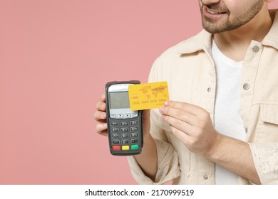 Close up cropped photo portrait shot young man in jacket white t-shirt hold wireless modern bank payment terminal to process and acquire credit card payments isolated on pastel pink background studio - Shutterstock ID 2170999519