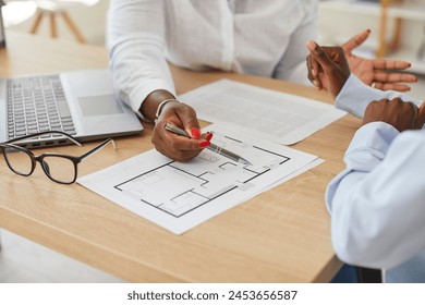 Close up cropped portrait of interior designer african american woman showing her client floor plan of new house. Female architect with blueprint construction project working at the desk in office. - Powered by Shutterstock