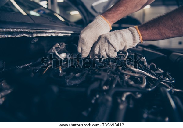 Close up cropped shot of experts appraisal of damage\
for repairing car at auto workshop, arms in white knitted gloves.\
Mounting specialist working at vehicle repair shop, brings new life\
to it