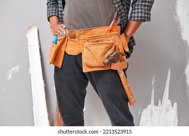 Close up cropped shot of a man wearing a tool belt with tools for home DIY - Powered by Shutterstock