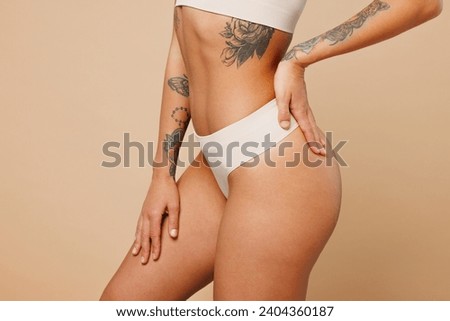 Close up cropped side view young nice lady woman with slim body perfect skin wear nude top bra lingerie stand put hands on thighs isolated on plain light beige background. Lifestyle diet fit concept