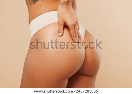 Close up cropped side view young lady woman with slim body perfect skin wear nude lingerie stand put hands on buttocks without cellulite isolated on plain beige background. Lifestyle diet fit concept