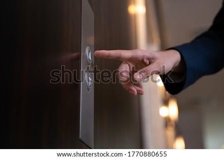 Close up cropped view of an unknown man taking the lift in a modern office or hotel