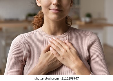 Close up cropped view young attractive Hispanic woman stand alone indoor put folded palms on chest feeling grateful and appreciation, express sincere feelings. Believe, charity, body language concept - Shutterstock ID 2113299947