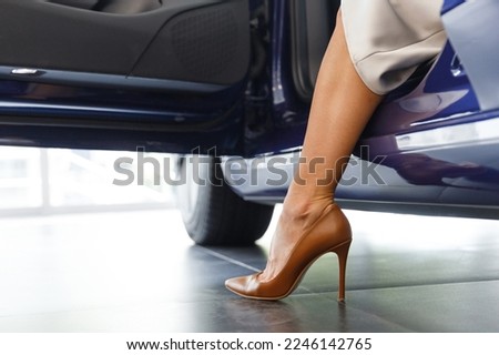 Close up cropped woman customer female buyer client wearing high-heels get out of car choose auto want buy new automobile in car showroom vehicle salon dealership store motor show indoor Sales concept