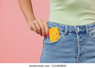 Close up cropped young woman 20s years old wears mint t-shirt jeans hold in pocket credit bank card isolated on plain pastel light pink background studio portrait. Achievement career wealth concept - Shutterstock ID 2114304833