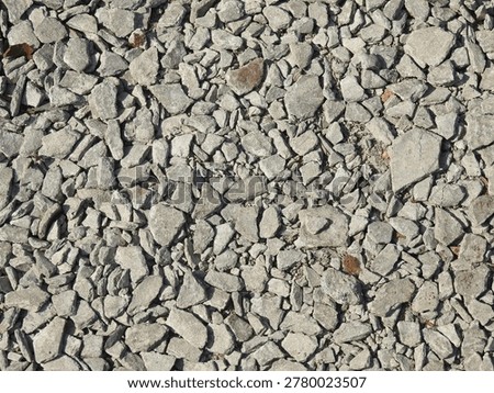 Close up of crushed stone featuring rough gravel texture, irregular rock fragments, and natural mineral tones. Commonly used in construction, landscaping, and road base applications. Ideal for industrial and texture background themes
