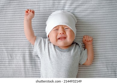 Close Up Of A Crying Newborn Laying On A Striped Gray Nappy. Hangry Baby. Infantile Colic. Baby Care