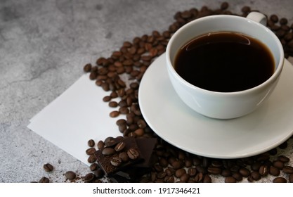 Close Up Of A Cup Of Coffee Surrounded With Coffee Beans And A Sticker For Text. Top View