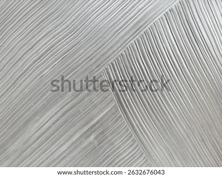 Close up of curvy fluted wall panel in random curves and waves crossing each other. weaving concept. Striped and fluted panel in silver grey metallic paint finish. Seamless background texture.