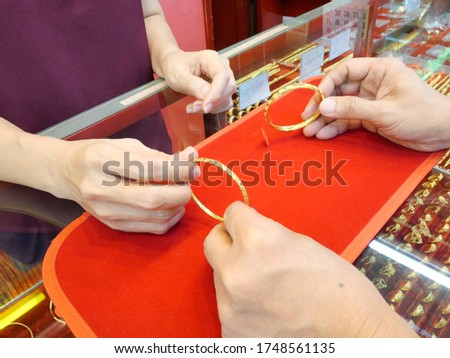 Close up of customer is checking bracelet before sell or buy at gold/pawn shop.