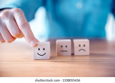 Close up customer hand choose smiley face and blurred sad face icon on wood cube, Service rating, satisfaction concept. - Shutterstock ID 1338055436
