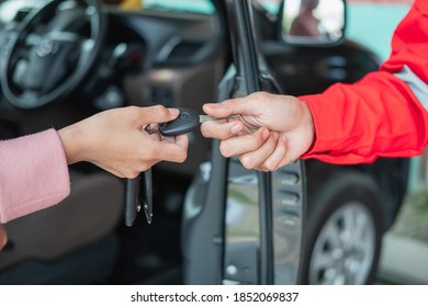 close up of customer hand giving car keys to mechanic with workshop background - Powered by Shutterstock