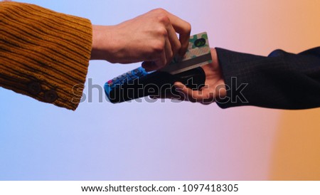 Close up of customer paying by credit card. Stock. Payment for purchase by Bank transfer on a colored background