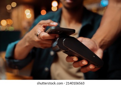 close up of customer paying with cellular device and card machine