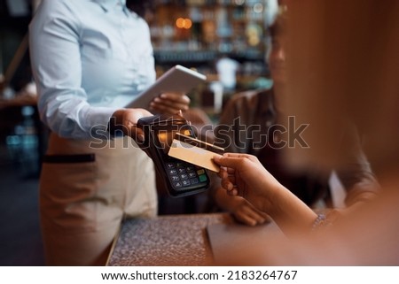 Close up of customer paying with credit card in a restaurant.
