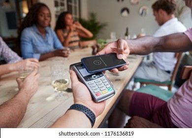 Close Up Of Customer In Restaurant Paying Bill With Contactless Phone App