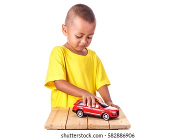 Close Up Cute Asia Little Boy Holding Red Toy Car. Portrait In Studio Shot. Isolated On White Background.