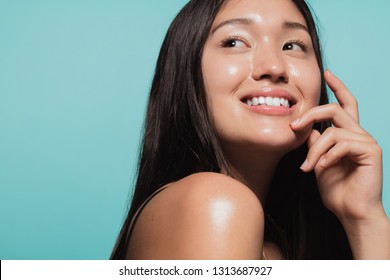 Close up of cute asian girl with glowing skin against blue background. Beautiful face of girl with fresh healthy skin. - Shutterstock ID 1313687927
