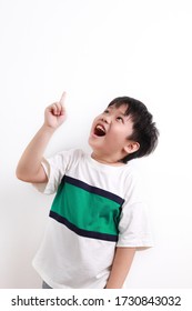 Close up cute little Asian boy having a good idea, finger pointing up, looking up, mouth open isolated on white background