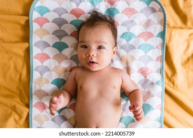 Close Up Of Cute Smiling Latino Baby Girl In Bed With Morning Light. Waking Up In Bed. Healthy Hispanic Baby With Warm Natural Light