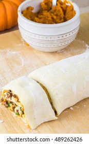 Close Up Of Cutting Board With Rolled And Cut Unbaked Beef Pumpkin Pinwheels