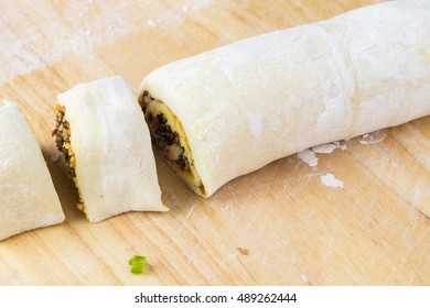 Close Up Of Cutting Board With Rolled And Cut Unbaked Beef Pumpkin Pinwheels