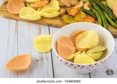 Close Up Of Cutting Board With Veggie Chips.